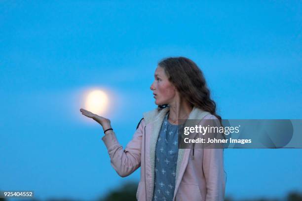 teenage girl with moon on background - face on the moon stock pictures, royalty-free photos & images