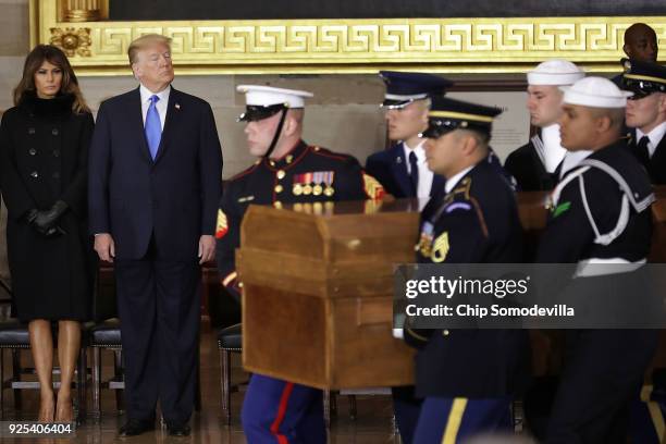 President Donald Trump and first lady Melania Trump watch Christian evangelist and Southern Baptist minister Billy Graham's casket arrive in the U.S....