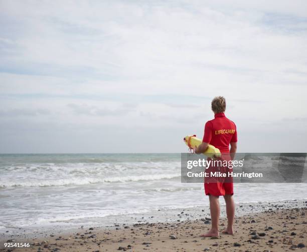 lifeguard on beach looking at the sea - lifeguard stock pictures, royalty-free photos & images