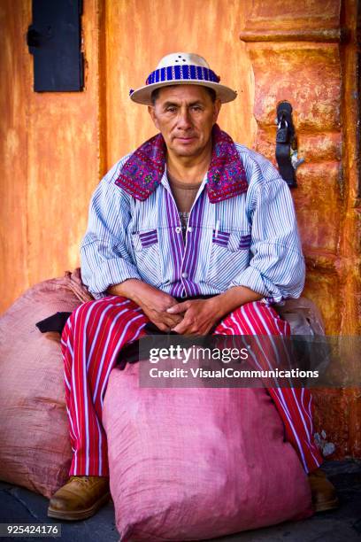 maya-mann sitzt vor haus in antigua, guatemala. - antigua guatemala stock-fotos und bilder