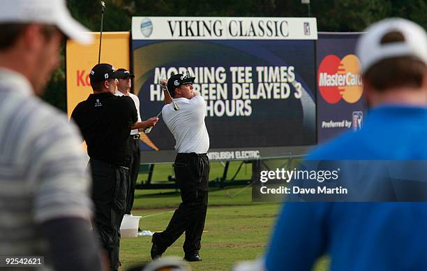 Roland Thatcher, center, hits balls on the range as he waits to hear if first round play will begin in the Viking Classic at the Annandale Golf Club...