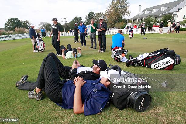 Caddies lie on the putting green as they wait for a PGA Tour decision on whether they would begin first round play in the Viking Classic at the...