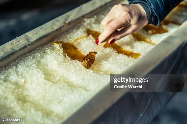 person gießen rollenden ahornsirup im sugar shack - bonbon stock-fotos und bilder