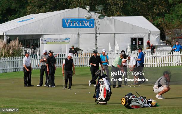 Golfers work on the practice green as they wait for word on when first round play will begin in the Viking Classic at the Annandale Golf Club on...