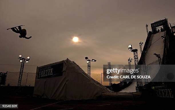 Snowboarder is silhouetted as he takes part in a qualifying session at the Battersea power station, in London, on October 30, 2009. The session took...