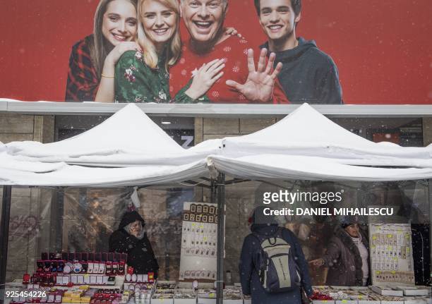 Market vendors sell traditional spring charms, "martisor" under makeshift shelters in central Bucharest on February 28, 2018. Romanians will be...