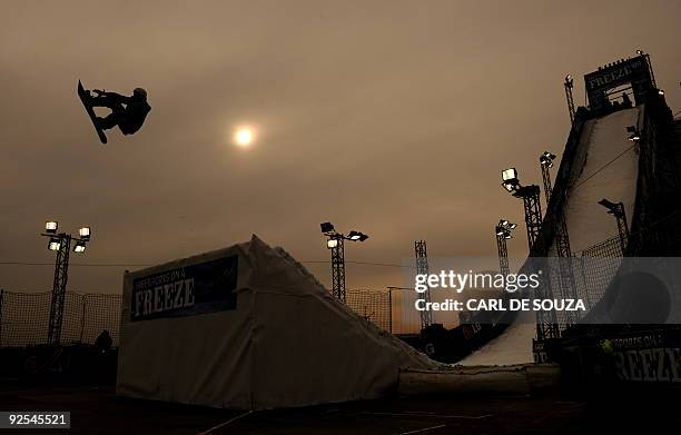 Snowboarder is silhouetted as he takes part in a qualifying session at the Battersea power station, in London, on October 30, 2009. The session took...