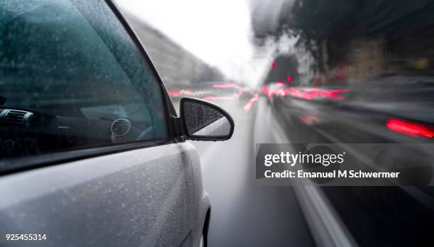 car drives through a rainy city - driving rain stock pictures, royalty-free photos & images