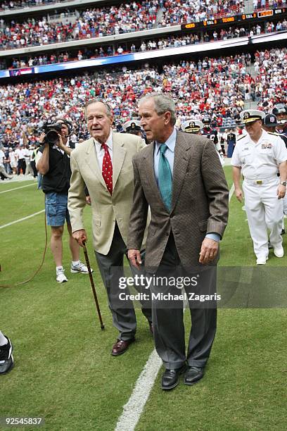 Former US Presidents' George W. Bush and George H.W. Bush walk on the field before the game between the San Francisco 49ers and Houston Texans at...