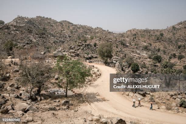 Women walk on the road to Mokolo on the outskirts of Koza on February 20 Far-North Region, Cameroon. Since 2014, the Far North region of Cameroon has...