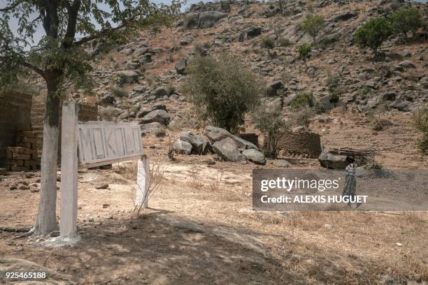 Woman carries a bundle of wood at the entrance to the town of Mokolo on February 20 Far-North Region, Cameroon. Since 2014, the Far North region of...