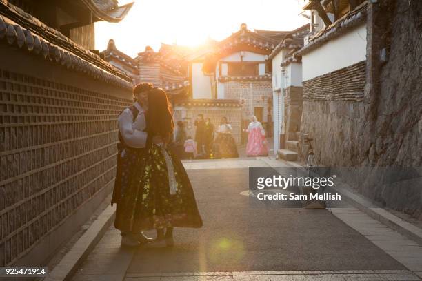 Couple dressed in Hanbok's, traditional Korean clothing, kiss in Bukchon Hanok Village on 26th February 2018 in South Korea. The Bukchon Hanok...