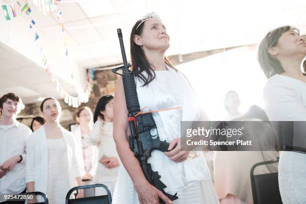 Woman holds an AR-15 rifle during a ceremony at the World Peace and Unification Sanctuary on February 28, 2018 in Newfoundland, Pennsylvania. The...