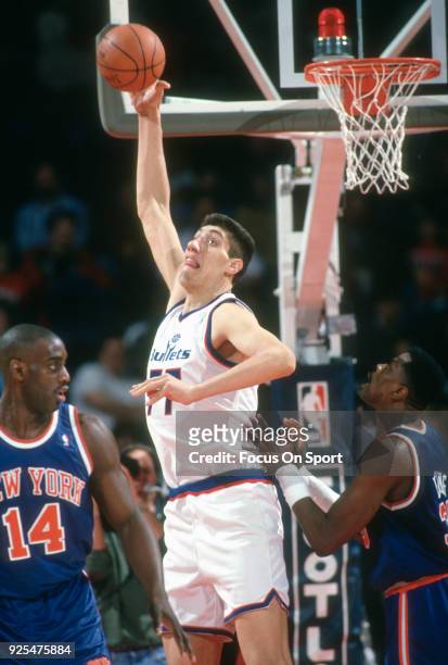 Gheorghe Muresan of the Washington Bullets grabs a rebound over Patrick Ewing of the New York Knicks during an NBA basketball game circa 1994 at the...