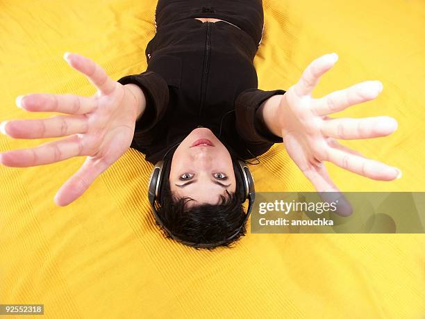 mulher ouvir música em amarelo mãos para a câmara - wide angle imagens e fotografias de stock