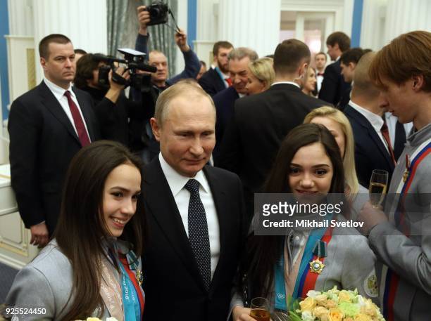 Russian President Vladimir Putin poses for a photo with figure skaters, Olympic champions Alina Zagitova and Evgenia Medvedeva during his meeting...