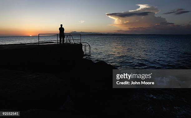 Army soldier watches the sun set over the Caribbean Sea October 28, 2009 at the U.S. Naval Base at Guantanamo Bay, Cuba. The base, currently best...