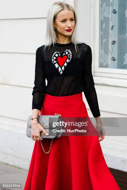 Victoria Magrath is seen wearing red skirt, a Dior sweater and a Dior Bag in the streets of Paris before the Dior show during Paris Fashion Week...