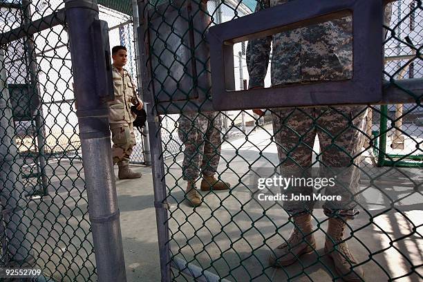 Military personnel stand at fenced recreation areas inside the U.S. Military prison for 'enemy combatants' on October 27, 2009 in Guantanamo Bay,...