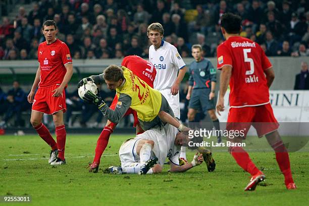 Goalkeeper Michael Ratajczak of Duesseldorf falls over Sebastian Langkamp of Karlsruhe during the Second Bundesliga match between Fortuna Duesseldorf...