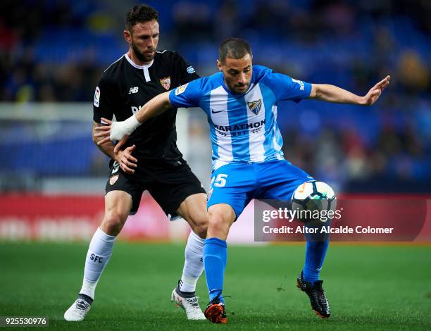 Miguel Layun of Sevilla FC duels for the ball with Medhi Lacen of Malaga CF during the La Liga match between Malaga CF and Sevilla FC at Estadio La...