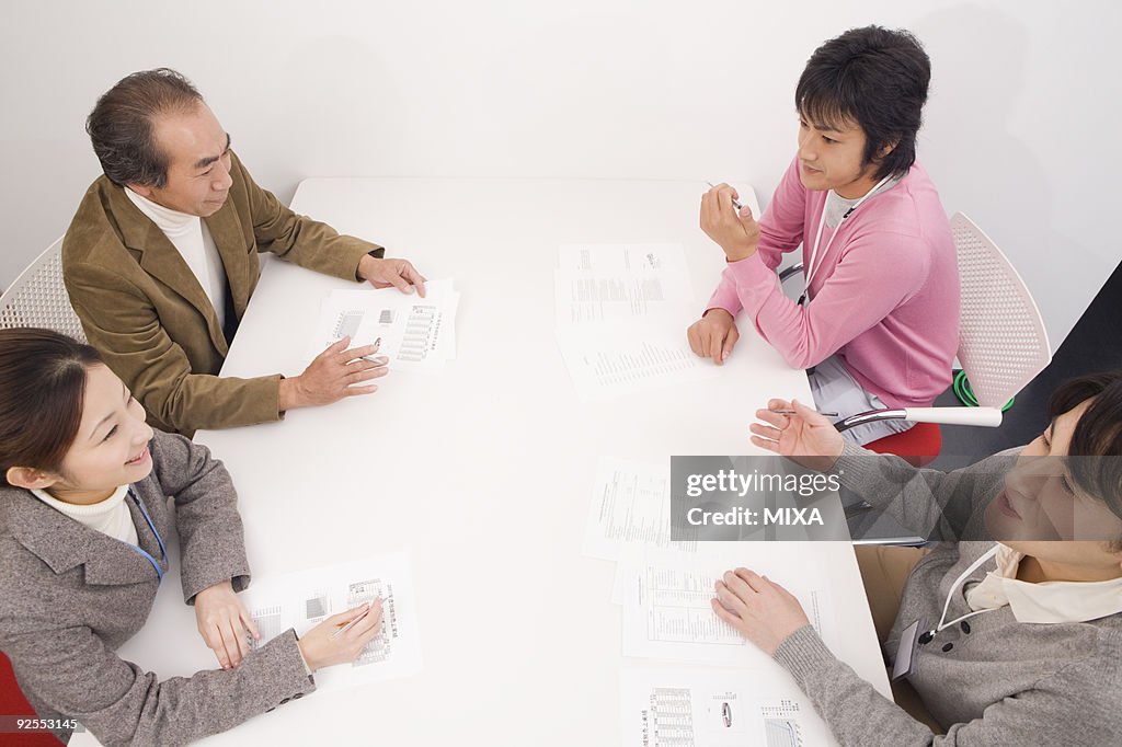 Four people discussing in meeting room
