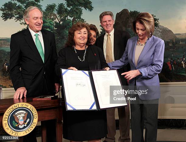 Jeanne White-Ginder, Ryan White's mother, holds the Ryan White HIV/AIDS Treatment Extension Act of 2009 after President Barack Obama signed it,...