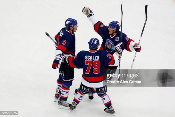 James Pollock of Mannheim celebrates his team's first goal with team mates Mario Scalzo and Frank Mauer during the DEL match between Adler Mannheim...