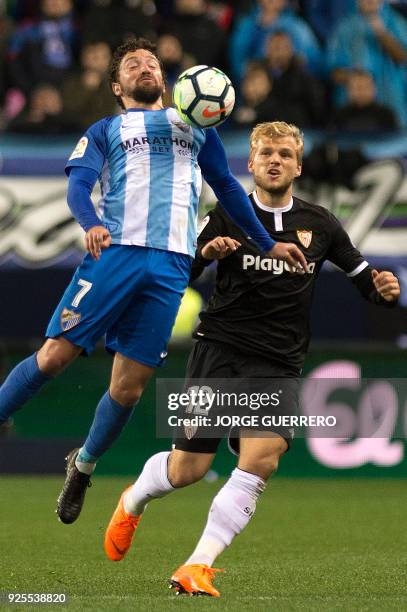 Malaga's Chilean midfielder Manuel Iturra vies with Sevilla's German midfielder Johannes Geis during the Spanish league football match Malaga CF...