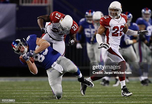 Kevin Boss of the New York Giants makes a catch as he is hit by Antrel Rolle of the Arizona Cardinals on October 25, 2009 at Giants Stadium in East...