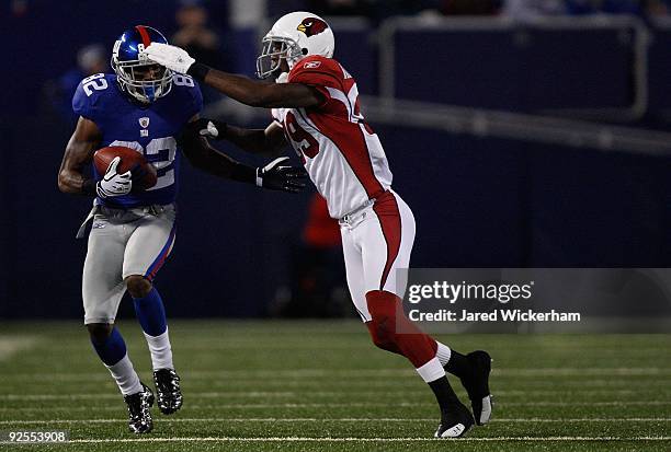 Mario Manningham of the New York Giants catches a pass in front of D. Rogers-Cromartie of the Arizona Cardinals on October 25, 2009 at Giants Stadium...
