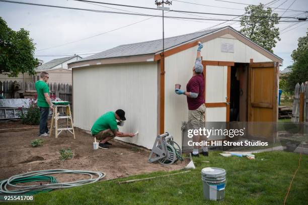 volunteering men painting shed - man shed stock pictures, royalty-free photos & images