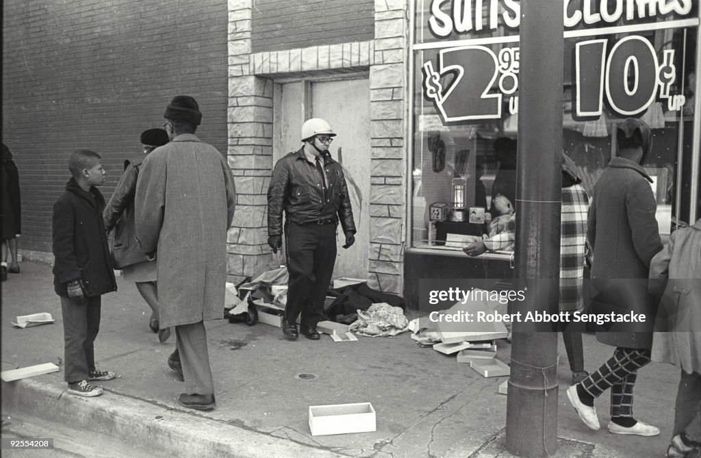 Chicago Riots 1968 Book As pedestrians walk past, a police officer stands neat a pile of ...