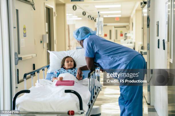 doctor holding hand of girl in hospital gurney - bår på hjul bildbanksfoton och bilder