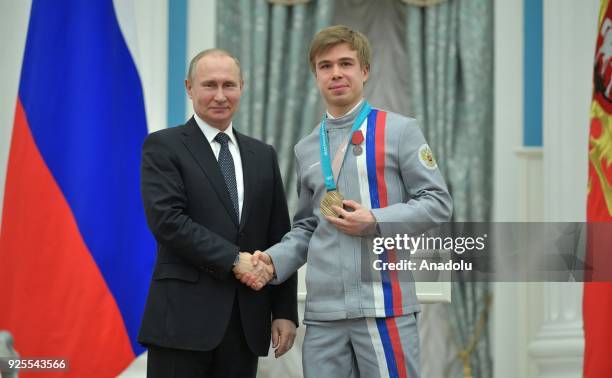 Russia's President Vladimir Putin presents short track speed skater Semyon Yelistratov with an Order for Merit to the Fatherland at a ceremony to...