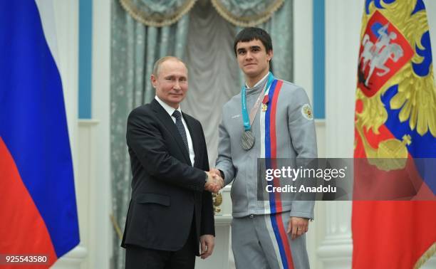 Russia's President Vladimir Putin presents skeleton racer Nikita Tregubov with an Order for Merit to the Fatherland at a ceremony to award Russian...