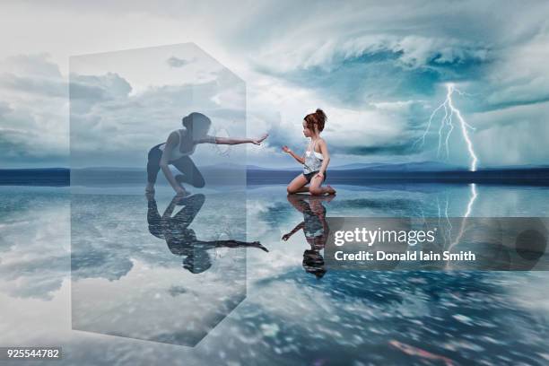 woman in cube reaching to kneeling girl - thunder girls stock pictures, royalty-free photos & images