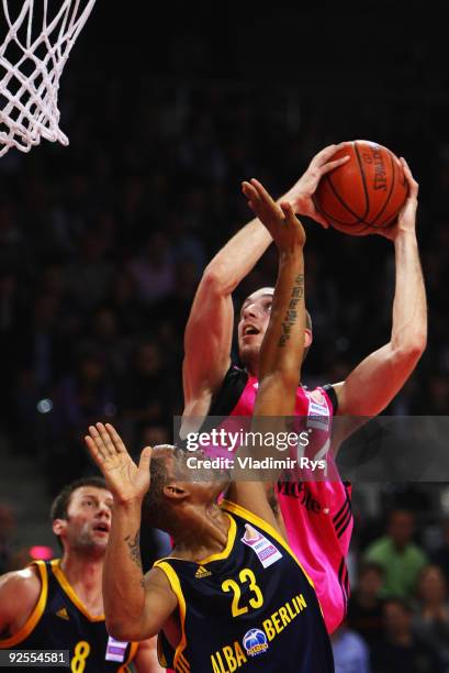 Tim Ohlbrecht of Baskets shoots defended by Immanuel McElroy of Alba during the Beko Basketball Bundesliga game between Telekom Baskets and Alba...