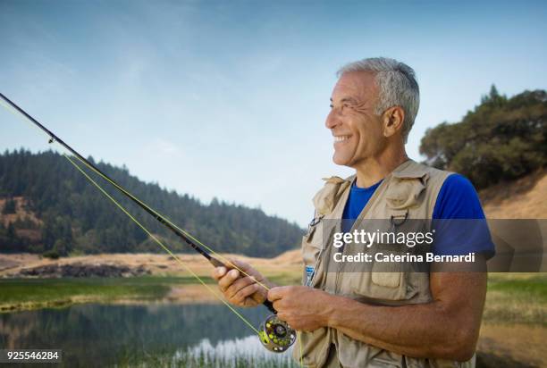 caucasian man fishing at river - fiskeväst bildbanksfoton och bilder