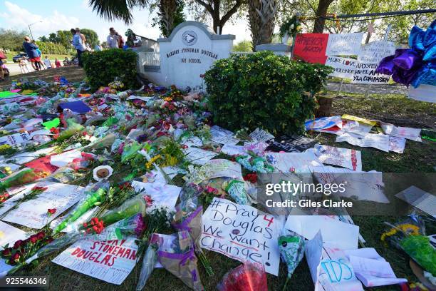 Flowers and signs are the entrance of the Stoneman Douglas High School. On February 14 a former school Stoneman Douglas student Nikolas Cruz entered...