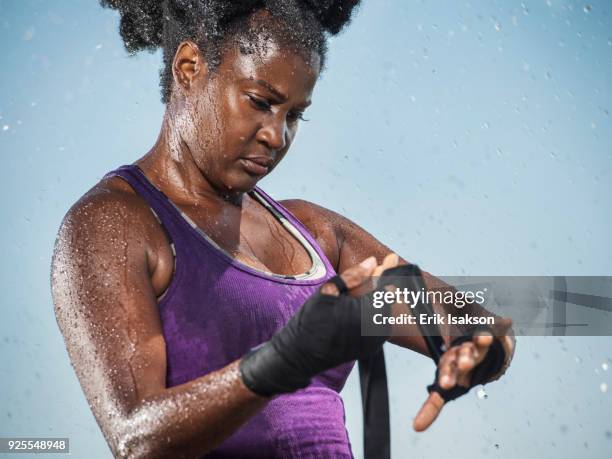 sweating black boxer wrapping hands - boxing media workouts fotografías e imágenes de stock