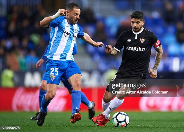 Medhi Lacen of Malaga CF competes for the ball with Ever Banega of Sevilla FC during the La Liga match between Malaga and Sevilla at Estadio La...