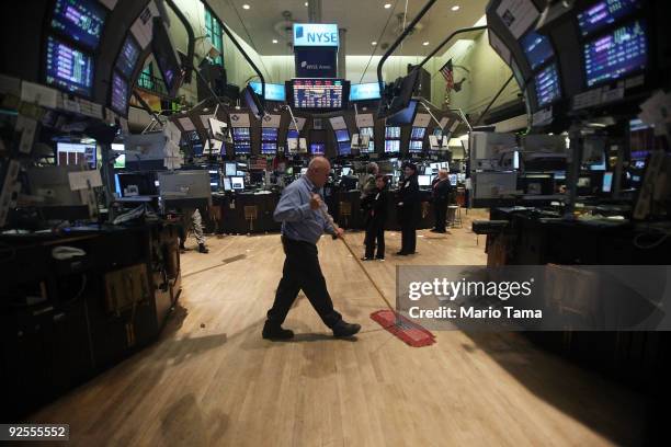 Worker sweeps the floor of the New York Stock Exchange after the closing bell October 30, 2009 in New York City. The Dow finished down 249.85 points...