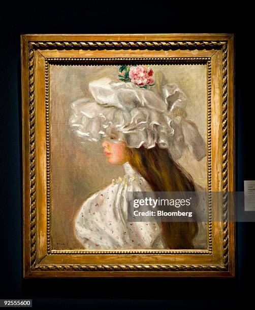 "Femme au Chapeau Blanc" by Pierre-Auguste Renoir hangs during a preview of the Impressionist and Modern Art fall sales at Sotheby's in New York,...