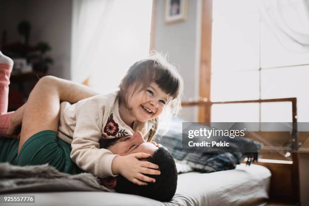 père et fille - amour et bonheur - sauter sur le lit photos et images de collection