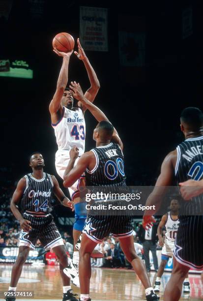 Pervis Ellison of the Washington Bullets shoots over Anthony Avent of the Orlando Magic during an NBA basketball game circa 1993 at the US Airways...