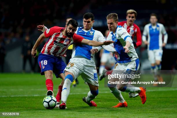 Diego Costa of Atletico de Madrid competes for the ball with Ezequiel Munoz of Deportivo Leganes and his teammate Raul Garcia during the La Liga...