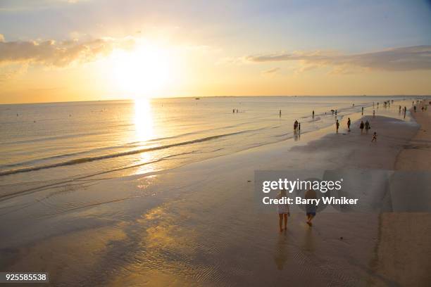 light clouds in blue sky above golden beach, with people at waterline awaiting sunset, ft. myers beach - waterline ストックフォトと画像