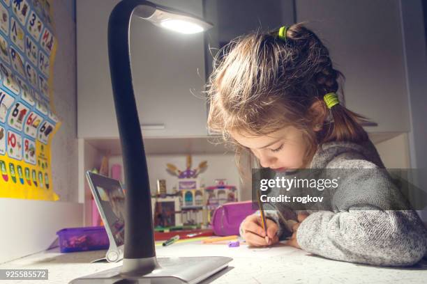 the girl draws at the table in the light of the lamp - kids bright colour room stock pictures, royalty-free photos & images