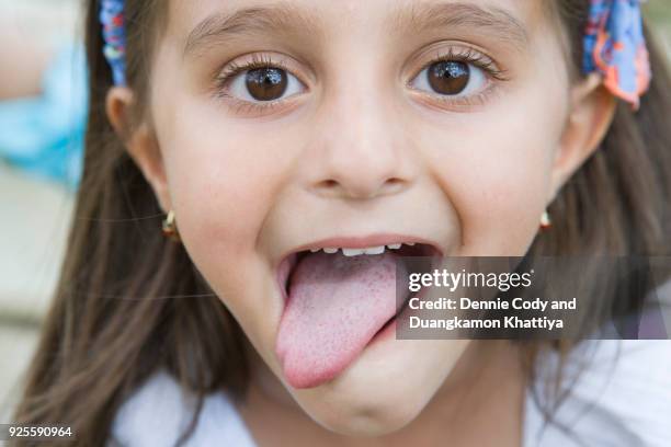 5 year old girl making funny face - tongue out stock pictures, royalty-free photos & images